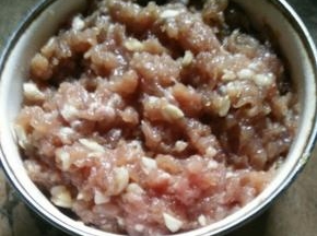 猪肉剁碎，加入蒜蓉、耗油、生抽、料酒、盐和淀粉，搅拌均匀后腌半个小时左右。