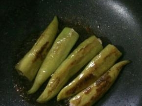 小火煎至尖椒两面有虎皮，盛出。