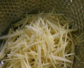 土豆去皮刨丝，用水冲洗几次后再泡水。