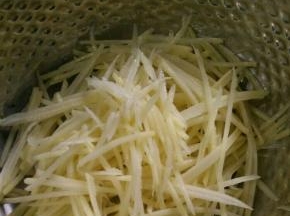 土豆去皮刨丝，用水冲洗几次后再泡水。