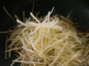然后倒入沥水后的土豆丝，快速翻炒。