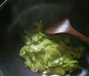 热锅凉油下蒜蓉和苦瓜，快速翻炒均匀。