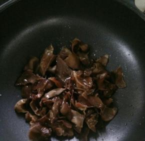 倒入木耳，翻炒片刻。