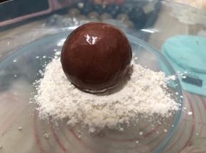把月饼放在面粉中滚一圈，月饼拿出把表面多余的面粉拍掉， 
模具装好花片，装入少许面粉滚一圈，再把面粉磕出来，把月饼放入模具中，
按压花纹的时间要用巧劲，不能用满力哦