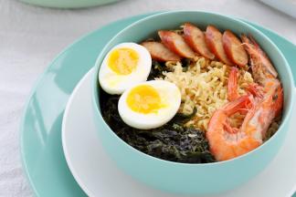 准备一个大碗，放入蛋面，倒入汤汁、紫菜，摆放好溏心蛋、鲜虾和脆肠。