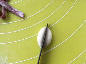 取一小块白色面团，搓成球，之后用刀对切成两份，做大白熊的手，面团分量大约3克左右