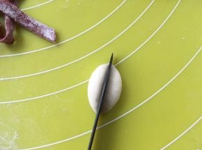 取一小块白色面团，搓成球，之后用刀对切成两份，做大白熊的手，面团分量大约3克左右