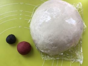 之后盖保鲜膜松弛，取两小份面团，分别加入竹碳粉跟红曲粉，揉成黑色跟红色两个面团