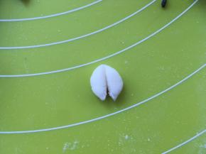 取一份1克左右的白色面团，搓成球，对切开，做大白熊的耳朵