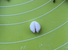 取一份1克左右的白色面团，搓成球，对切开，做大白熊的耳朵