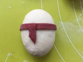 再剪下一小块红色面条，沾点水，黏在红色围巾的一侧