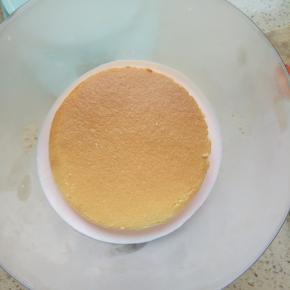 模具底部倒一点慕斯糊放一片小蛋糕片，因为模具是球形的，所以要先倒一点慕斯糊以填满模具底部，放入冰箱冷冻10分钟