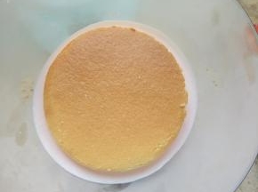 模具底部倒一点慕斯糊放一片小蛋糕片，因为模具是球形的，所以要先倒一点慕斯糊以填满模具底部，放入冰箱冷冻10分钟