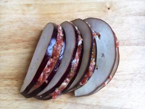 将调好的肉靡夹在茄子片里，刮去周边多余的肉靡。