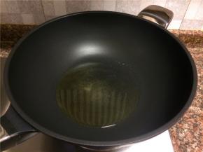 热锅倒油烧至八成热。