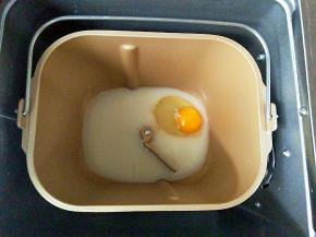 准备做排包的材料，把牛奶，鸡蛋放入面包机桶