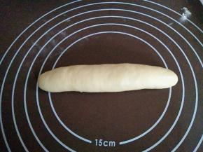 一边从上往下用力按压，一边转动面团，搓成约18厘米的棒状