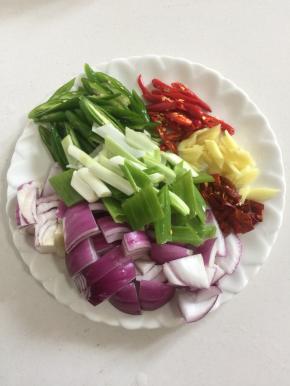 把洋葱洗净切成块儿，青尖椒和红尖椒洗净切成块，生姜切成丁，蒜瓣剁碎，干辣椒切成段，大葱切成段备用。