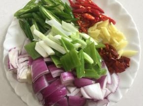 把洋葱洗净切成块儿，青尖椒和红尖椒洗净切成块，生姜切成丁，蒜瓣剁碎，干辣椒切成段，大葱切成段备用。