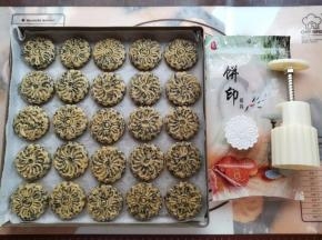 用月饼模具把芝麻桃酥面团压出花纹