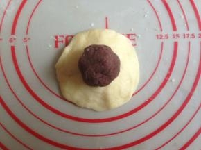 揉圆后压成圆形，放上红豆馅（提前将红豆馅分成每个15克）