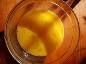 鸡蛋磕入碗中，加入黄酒打散