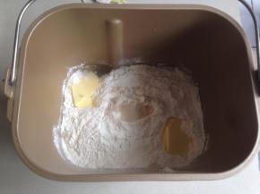 将水、糖和盐倒入东菱面包桶里，加入切成小块的黄油和面粉，在面粉顶端加入酵母