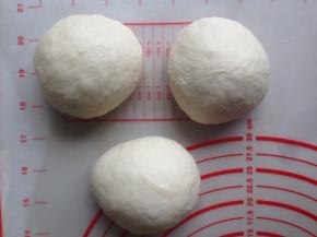 面团发酵好后，按压排气，分成3等份，滚圆，盖上保鲜膜松驰15分钟