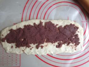 将面团擀成26CM长的长方形，下面那一条长边压薄，每一份抹上45克左右的红豆馅