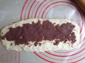 将面团擀成26CM长的长方形，下面那一条长边压薄，每一份抹上45克左右的红豆馅