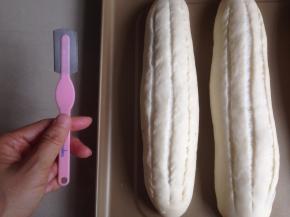 发酵好的面包坯明显大一些了，用面包割刀在面包坯上划3条长划口