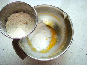 搅拌均匀后倒入玉米油和纯牛奶，继续搅拌均匀筛入面粉。