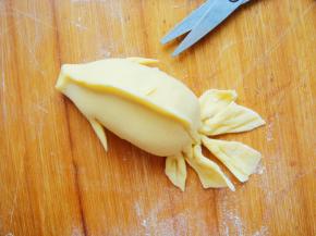 鱼身两侧用剪刀倾斜着剪出鱼鳍捏扁。