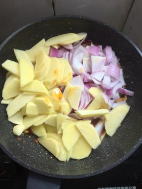 放入洋葱和土豆翻炒片刻。