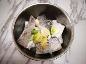 2.	带鱼撒上葱花和姜片，再倒入白酒拌匀，腌制30分钟，