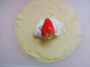 11.	小心取出饼皮，并盖上一层保膜，依次将面糊都煎完，一张饼皮，一勺淡奶油，再放上草莓，再一勺淡奶油，