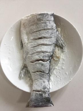 腌制好的鱼擦干水分，在鱼身上两面都均匀的涂抹一层玉米淀粉，再把鱼提起来，拍掉鱼身上多余的淀粉。