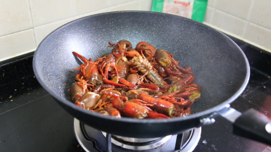 倒入小龙虾，大火翻炒，加入料酒翻炒均匀