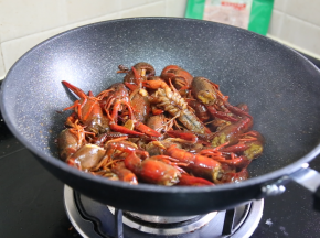 倒入小龙虾，大火翻炒，加入料酒翻炒均匀