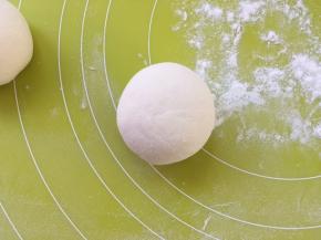 手上沾点干粉，将包裹好的面团搓圆