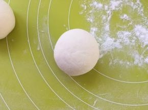 手上沾点干粉，将包裹好的面团搓圆