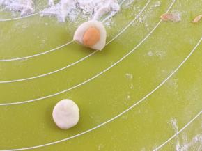 取一小块白色面团，搓成球压扁，再取一小块橙色面团，搓成球，压在白色面团中间做耳朵