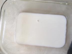 我用的方形玻璃保温盒，擦干净，倒入薄薄的一层牛奶，入冰箱冷藏至凝固