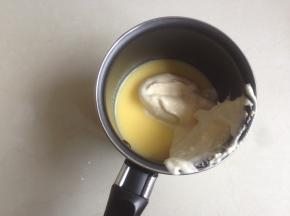 舀一勺蛋糕糊到已经融化为液体的黄油牛奶液里，拌匀