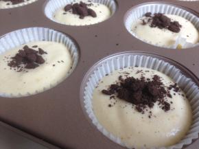 挤入放了纸杯模的蛋糕模具中，可以做9-10个，在桌面上震出气泡，撒点奥利奥饼干碎在上面