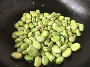 热锅凉油，放入葱花爆香，放入蚕豆，翻炒均匀。