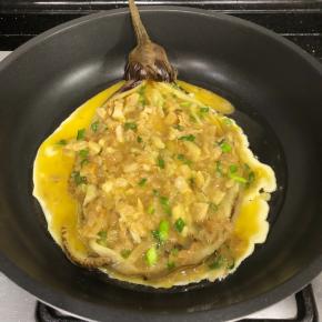 不粘锅放油，将裹好蛋液的茄子入锅煎制。