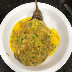 将拌好的鸡蛋液倒入摊开的茄子上