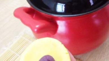 取一个南瓜剂子捏成薄片状，再放入紫薯馅心。