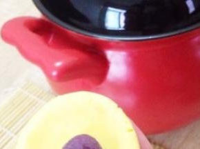 取一个南瓜剂子捏成薄片状，再放入紫薯馅心。